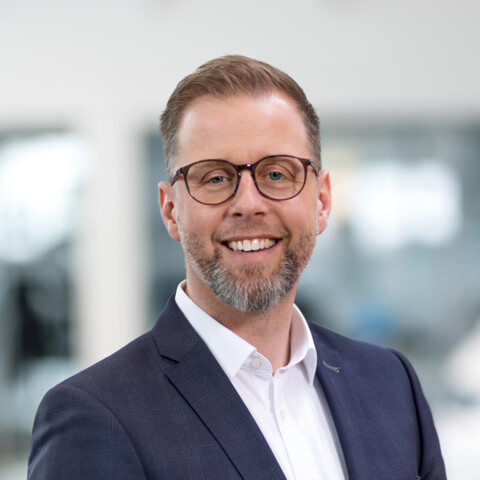 Porträt von Steven Klatt, Verkaufsleiter für Nutzfahrzeuge, lächelnd in einem modernen Autohaus.
