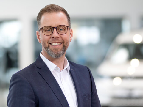 Porträt von Steven Klatt, Verkaufsleiter für Nutzfahrzeuge, lächelnd in einem modernen Autohaus.